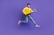 © deagreez - Full body photo of nice young male running hold suitcase traveler dressed stylish yellow outfit isolated on purple color background