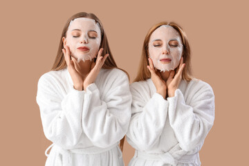 Wall Mural - Young woman and her mother in bathrobes with facial sheet masks on beige background