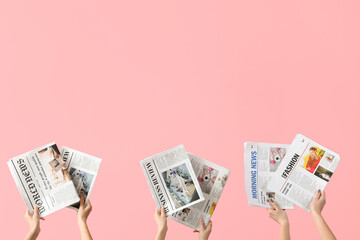 Wall Mural - Women with newspapers on pink background