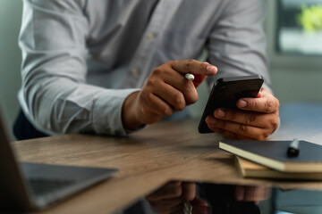 Poster - businessman holding a smartphone in the office, working online, looking mobile Communication and technology concepts