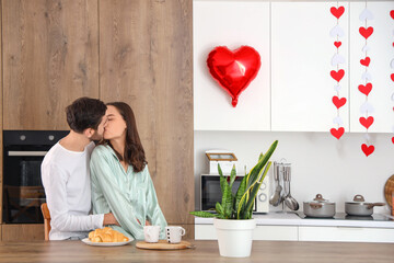 Poster - Happy young couple kissing in kitchen on Valentine's Day