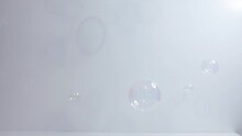 Clear Bubbles Falling In Front Of White Background
