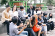 © Gatot - Group of businesspeople sitting together having fun while break outside the office