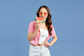 Wall Mural - Young Asian woman eating watermelon on background