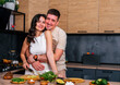 © dvulikaia - Happy romantic couple cooking together at the kitchen.