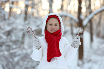 Sticker - Cute little girl with candy canes in winter park