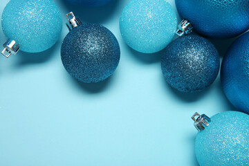 Wall Mural - Christmas balls on light blue background, top view. Space for text