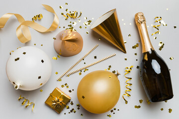 Wall Mural - Flat lay composition of Champagne bottle gift box ribbons and confetti on colored background. Flat lay, top view holiday concept