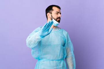 Wall Mural - Surgeon man with beard with blue uniform over isolated purple background making stop gesture and disappointed