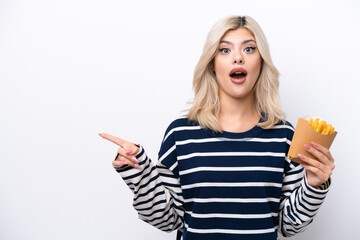 Canvas Print - Young Russian woman catching french fries isolated on white background surprised and pointing side