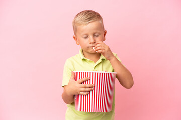 Little Russian boy eating popcorns in a big bowl over isolated background