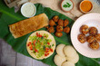 South Indian Platter Dish, Masala Dosa, Vada, Idli, Uttapam, Appam, Upma, Sambar and Coconut Chutney on a banana leaf in copper plate. South Indian Platter.