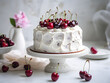 Delicious cake with vanilla buttercream frosting and fresh cherries on top, white table and blurry background 