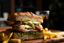 Grilled Chicken Breast Sandwich With Lettuce, Tomato, Bacon, Red Onion Rings And Avocado Served On Artisan Bread And A Portion Of French Fries