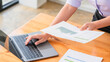 © Pichsakul - Businesswomen reading document and typing data on laptop while thinking about strategy of startup