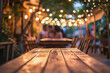 A romantic outdoor dining setting with a wooden table under a canopy of twinkling lights and a blurred couple in the background
