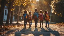 Five Children Walking Down The Street With Backpacks