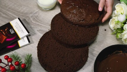 Wall Mural - Woman's hands cutting chocolate biscuit into pieces on kitchen table