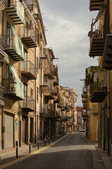 Canvas Print - Castelbuono, Italy-October 28,2023:Authentic landscape view of small medieval village Castelbuono. Vintage colorful buildings with typical balconies with drying underwear. Travel and tourism concept