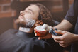 © Parilov - Brush for shaving beard along, blurred background of hair salon for men, barber shop.