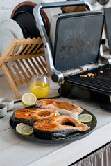 Wall Mural - grilled trout steak ready to be cooked on electric grill in the kitchen