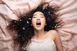 © Magryt - Young asian woman having orgasm. Woman with open mouth and closed eyes enjoying sex lying among flying glitter and sparkles as a symbol of orgasm. Sexual experience, masturbation, cunnilingus.