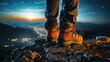 A person standing on top of a mountain at night in trekking boots