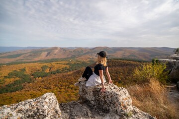 Wall Mural - woman on mountain peak looking in beautiful mountain valley in autumn. Landscape with sporty young woman, blu sky in fall. Hiking. Nature
