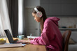 © Home-stock - Focused teen girl wearing headphones studying online with laptop from home, making notes, doing homework. Remote education concept
