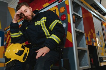 Wall Mural - A seated and sweating firefighter is exhausted, distressed and tired after being overwhelmed in a rescue operation