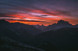 Fototapeta Góry - Dark red sky at Italian Dolomites with mountain peaks in distance. Twillight hour at Italian Alps. 