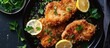 Panko breaded pork chops with lemon and parsley on a black plate, viewed from above.