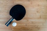 Fototapeta Tęcza - Paletka i piłeczka do tenisa stołowego leżąca na blacie bambusowym