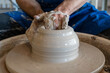 Potter throwing a pot on the wheel in a studio