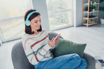 Poster - Portrait of lovely peaceful girl sit comfy chair listen music use smart phone chilling modern interior flat indoors