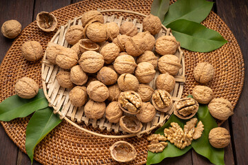 Wall Mural - Walnuts in wooden bowl on wooden background, Walnuts kernels in wooden basket on wooden table.