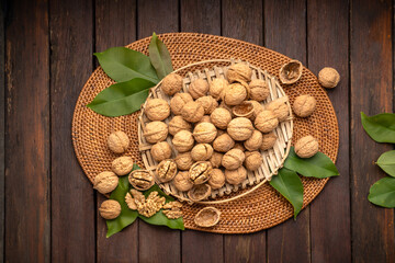 Wall Mural - Walnuts in wooden bowl on wooden background, Walnuts kernels in wooden basket on wooden table.