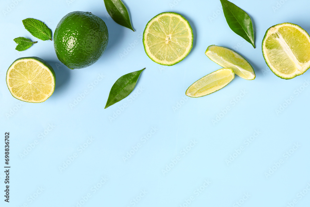 Slices of fresh lime with leaves on blue background