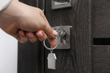 Wall Mural - Woman unlocking door with key, closeup view