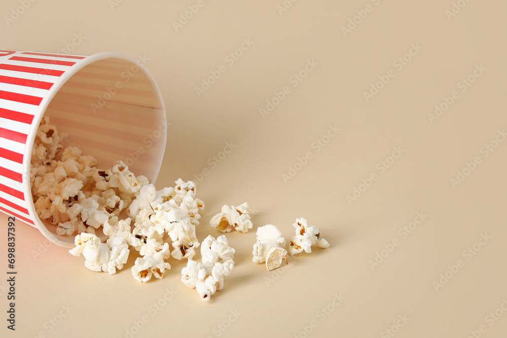 Bucket with tasty popcorn on beige background