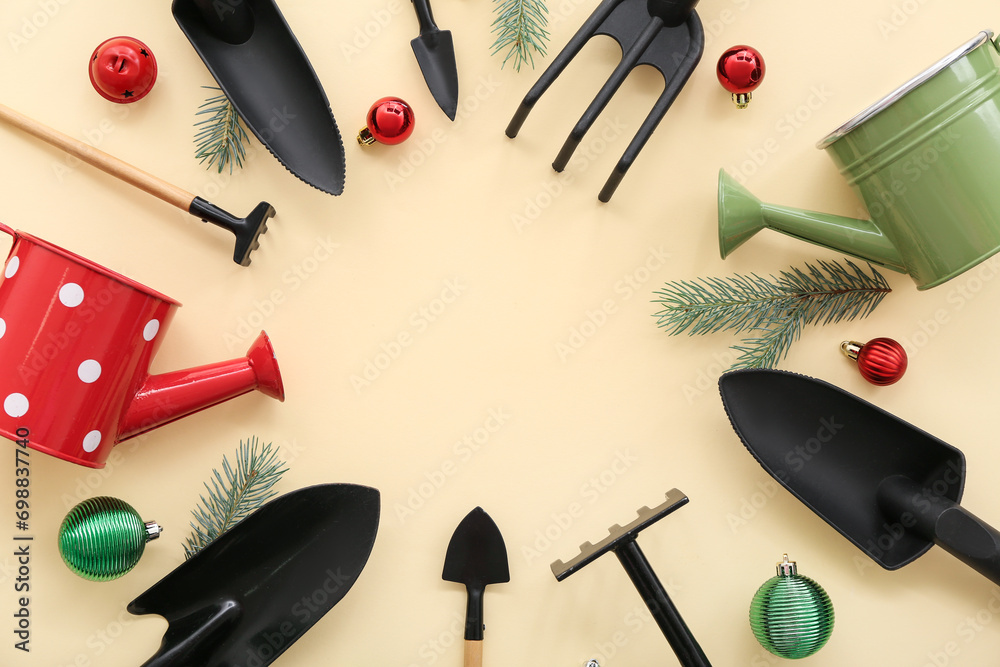 Frame made of gardening tools with Christmas decor on beige background