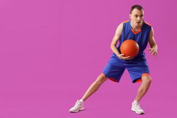 Wall Mural - Young basketball player on purple background