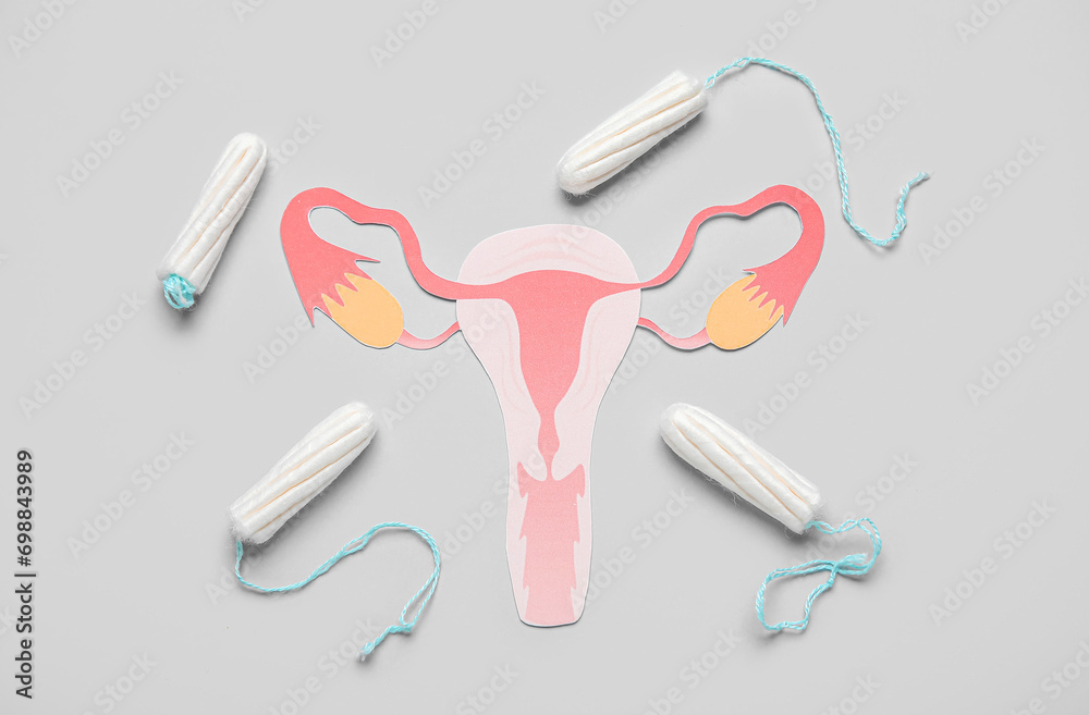 Composition with paper uterus and tampons on grey background