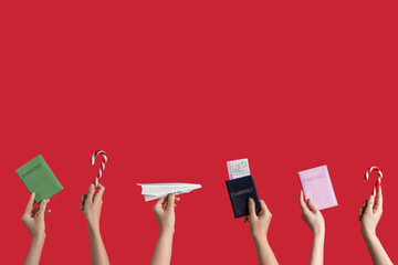 Wall Mural - Female hands holding passports, paper plane and candy canes on red background. New year vacation concept