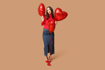 Poster - Beautiful young woman with heart shaped air balloons on brown background. Valentine's Day celebration