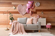 Interior of festive living room with grey sofa and heart-shaped balloons. Valentine's Day celebration