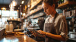 © Maykon - Waitress using digital tablet to view and manage orders in a coffee shop