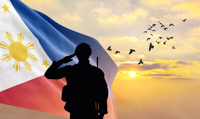 Wall Mural - Silhouette of a soldier with the Philippines flag stands against the background of a sunset or sunrise. Concept of national holidays. Commemoration Day.