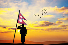 Silhouette Of A Soldier With The Nepal Flag Stands Against The Background Of A Sunset Or Sunrise. Concept Of National Holidays. Commemoration Day.