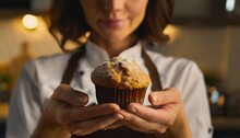 Close-up of chef's hands holding freshly baked muffin
